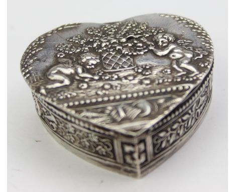 An antique heart shaped silver pill box or snuff box with embossed decoration of flowers and cherubs, gilt lined interior, im