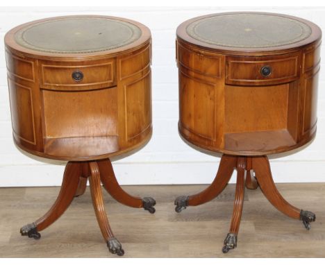 A pair of antique style mahogany drum tables with inset gilt tooled green leather tops, three drawers, splayed base and lion 