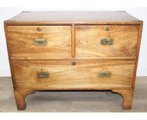 An antique camphorwood two over one chest of drawers with recessed brass campaign handles and bracket feet, likely military, 
