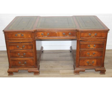 An antique style leather topped three part pedestal desk with break front recess, gilt tooled green leather inset top, nine d