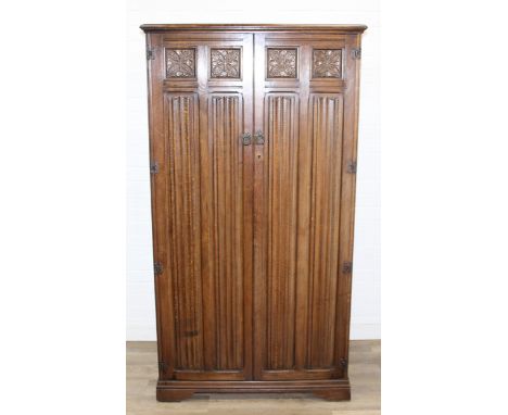 A Gothic style oak wardrobe with Linen fold panels, fitted interior, label for Crown AY furniture, 96cm x 58cm x 174cm