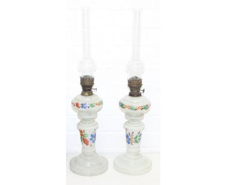 A pair of antique opaque glass oil lamps decorated with flowers, each 66cm tall [2]
