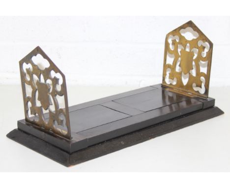 An antique extending coromandel and brass book-slide with brass fretwork book-ends/holders, 41cm (56cm extended)
