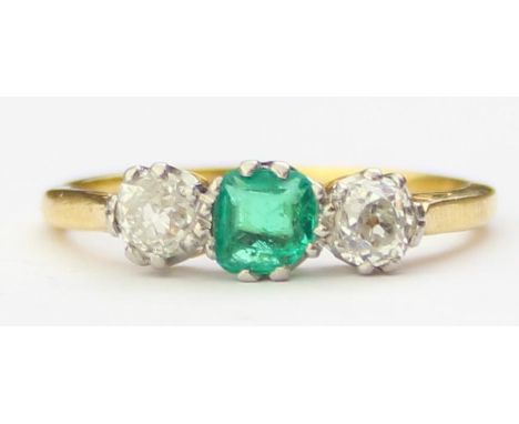 [2.41g, M] - an 18ct yellow gold ring set with two diamonds flanking an emerald, the diamonds assessed as 0.2ct each, marked 