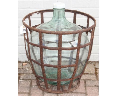 A large vintage glass carboy in iron basket, 52cm in diameter x 62cm tall