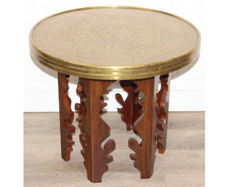 A small vintage brass topped table with Moorish style carved wooden base, 60cm in diameter x 50cm tall
