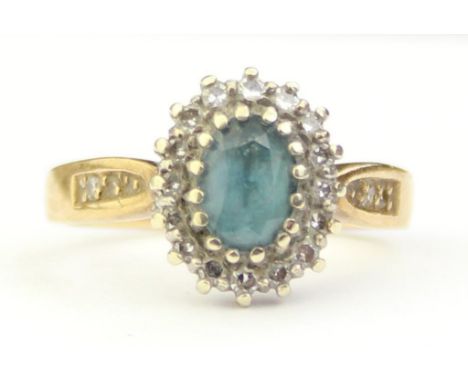 [3.65, M] - a vintage 9ct gold ring set with a light blue stone, believed to be an aquamarine and surrounded by small diamond