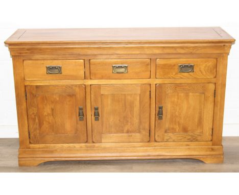 A good quality modern light oak sideboard with three drawers over three cupboards, bronzed metal fittings, 138cm x 43cm x 83c