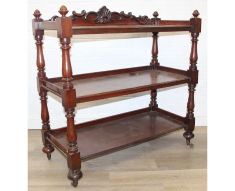 A 19th century mahogany three tier buffet stand with turned supports, carved back rail and castors, 104cm x 47cm x 107cm