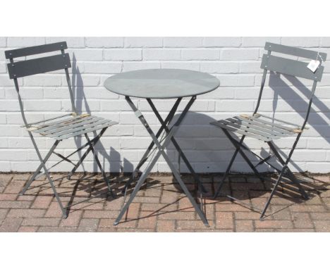 A folding metal bistro table and two folding chairs, the table 60cm in diameter