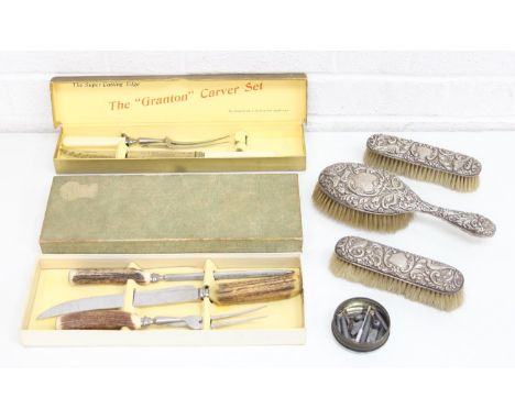 Two vintage cased carving sets, EPNS brush sets and tin of miscellaneous metalware