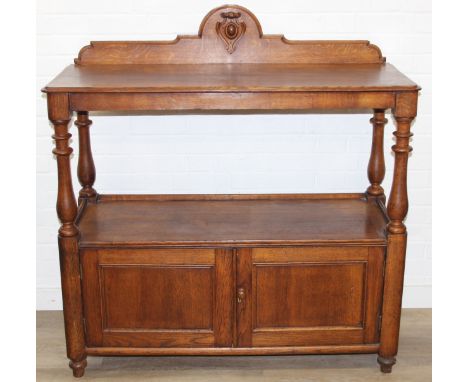 An antique oak two tier buffet stand with cupboard base and carved frieze to top, late 19th or early 20th century, 120cm x 50