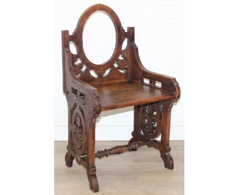 A 19th century oak gothic revival chair of small proportions with round back, possibly a chapel chair, 49cm wide x 84cm tall