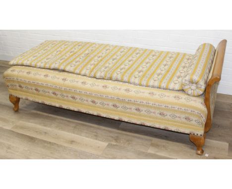 A Regency style day bed with patterned yellow and cream upholstery and exposed wooden legs, 188cm x 88cm x 64cm