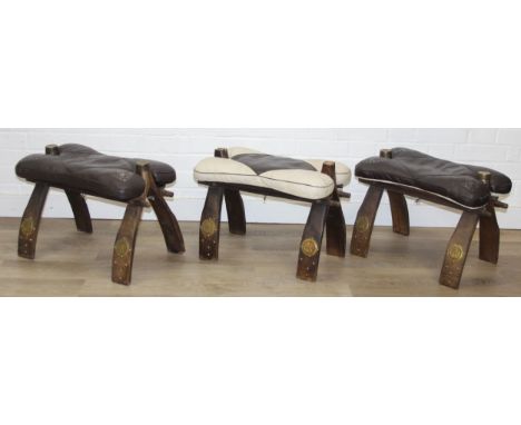 Three vintage camel saddle stools with brass mounts and leather and faux leather cushions [3] 