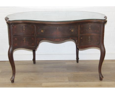 An early 20th century mahogany desk of unusual shaped form, Sheraton revival inlay and shaped legs, with glass top, approx 12