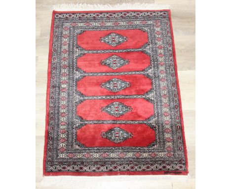 A red ground Uzbek style Bukhara rug, made in Pakistan, 138cm x 94cm