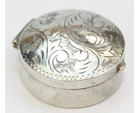 A small silver pill box with engraved scroll decoration, import marks for London 1978 by VM, 32mm in diameter, 10.88g