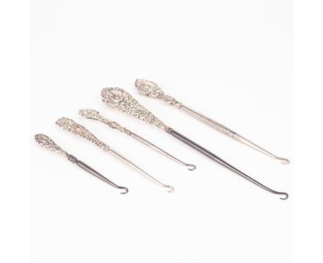 LARGE EDWARDIAN BUTTON HOOK, with rococo embossed silver handle, 10" long, Birmingham 1902, AND FOUR SIMILAR BUT SMALL BUTTON