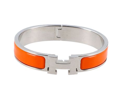 HERMÈS Armreif "CLIC H", NP.: 575,-€. Größe PM. Schmaler Armreif aus Email in Orange mit Palladiumauflage. Staubbeutel und Bo