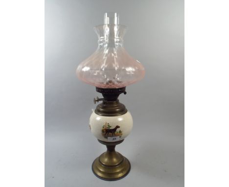 A Brass and Ceramic Oil Lamp with Sporting Dog Decoration 