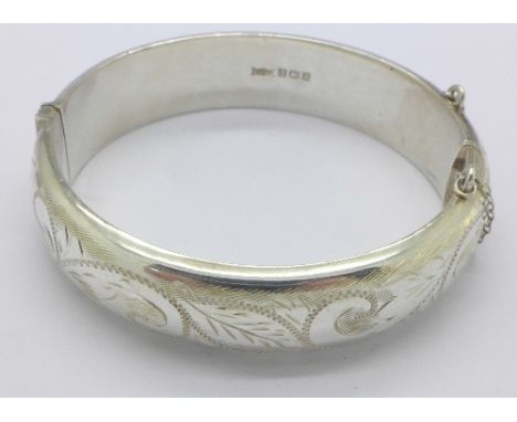 A silver engraved bangle with safety chain, Birmingham 1968-69, 24.2g