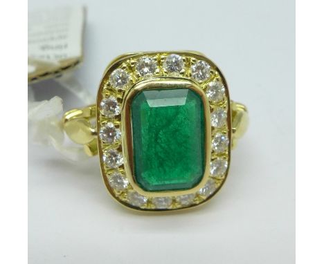 An 18ct gold set, emerald and diamond ring, set with sixteen brilliant cut diamonds, over 1 carat total weight, emerald appro
