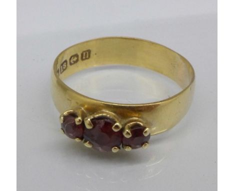 An 18ct gold, three stone garnet ring, Birmingham 1912, 3.3g, R