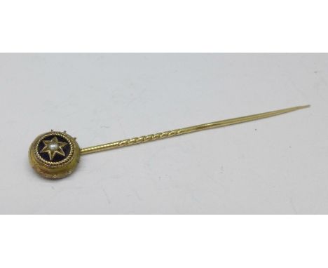 A yellow metal pearl set stick pin