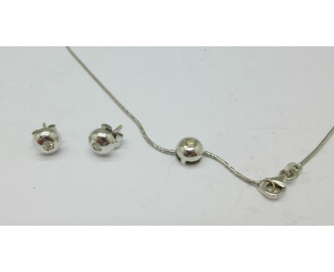 An 18ct white gold and diamond pendant and chain and a matching pair of earrings, 7.6g