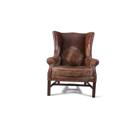 A GEORGE III MAHOGANY FRAMED WINGBACK ARMCHAIR, covered in  dark brown leather, with outscrolling arms and loose seat cushion