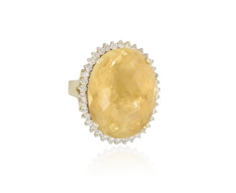 A CITRINE AND DIAMOND COCKTAIL RING, the oval mixed-cut citrine set within a surround of round brilliant-cut diamonds, mounte