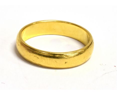A 22CT GOLD BAND RING Band width 4mm, ring size K, worn hallmark, possibly Birmingham, weight 4g
