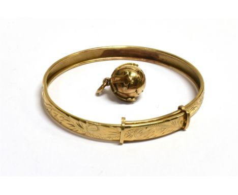 MASONIC ORB CROSS PENDANT AND A VINTAGE BANGLE  The gilt orb pendant stamped made in England, opens up to reveal a Masonic cr