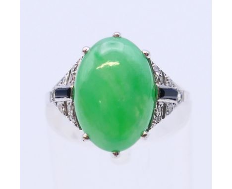 An Art Deco white gold or platinum jade, diamond and onyx ring. Ring size K/L.  4.2 grammes total weight. 