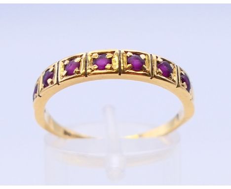 An 18 ct gold ruby set half eternity ring. Ring size S.