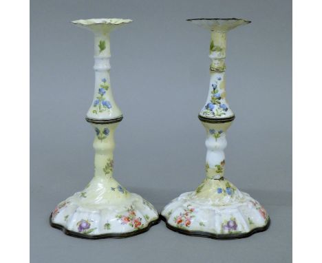 A pair of 18th/19th century Staffordshire enamel candlesticks, each with floral decoration. 16 cm high.