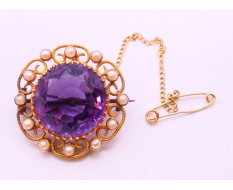 A 15 ct gold, amethyst and seed pearl brooch. 2.5 cm diameter.