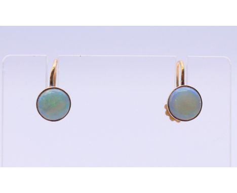 A pair of 9 ct gold and opal earrings. Each 6 mm diameter.