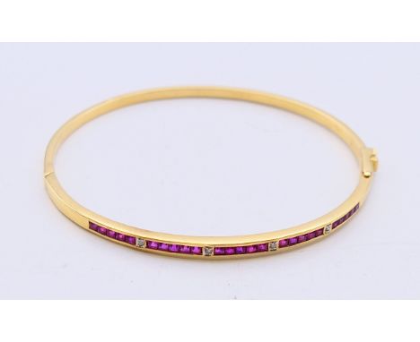 An 18 ct gold, ruby and diamond hinged bangle with twenty-five square shaped rubies (2mm), four brilliant cut diamonds (1.5mm
