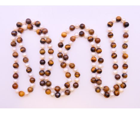 A tiger's eye and pearl necklace. 118 cm long.