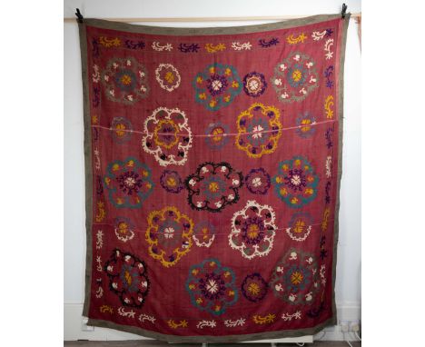 A VINTAGE SUZANI (UZBEKISTAN). Embroidered in chain stitch in coloured silk thread with foliate medallions reserved on a burg