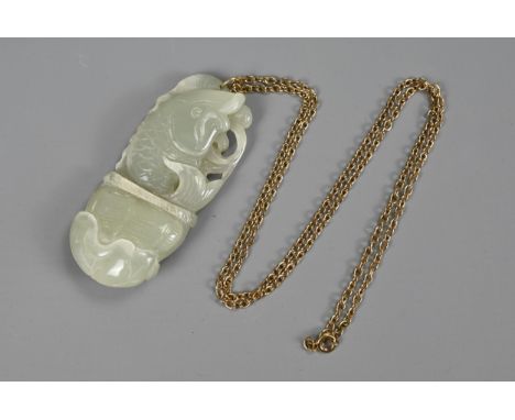 A CHINESE JADE PENDANT, 20TH CENTURY. Pale celadon carving in the form of a carp rising from a basket on lotus leaf. Attached