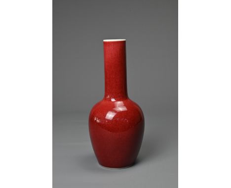 A CHINESE RED GLAZED PORCELAIN BOTTLE VASE, KANGXI MARK. Ovoid body leading into to a tall cylindrical neck covered in a deep