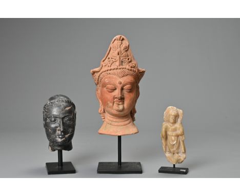 THREE STONE AND POTTERY FIGURES. To include a red pottery model of a head; A carved black stone head; Together with an alabas