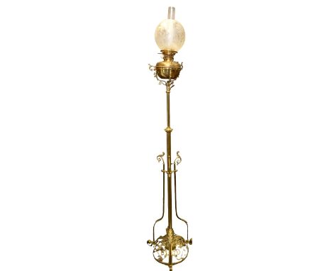 A late 19th century tall extendable ornate brass columned standing oil lamp, the base having central domed pierced brass area