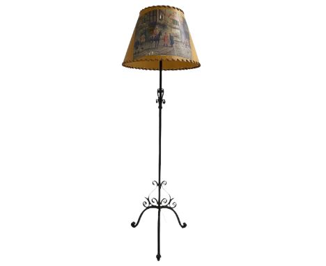 20th century wrought metal standard lamp, decorated with scrolls and on tripod base, with conical shade depicting hunting sce