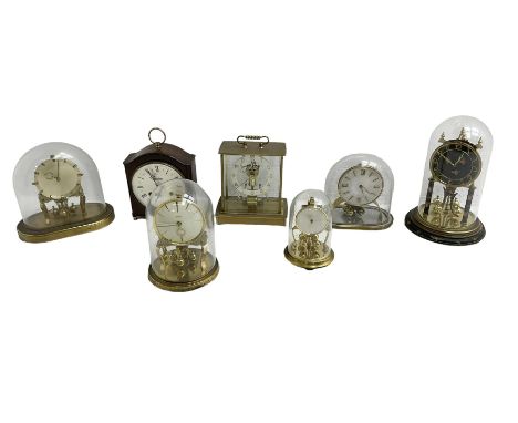Five 20th century torsion clocks, a striking mantle clock and a Kundo battery operated mantle clock with a solenoid oscillati