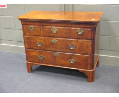A George I and altered walnut veneered chest of three small drawers above two long drawers, fluted canted sides, on slender s