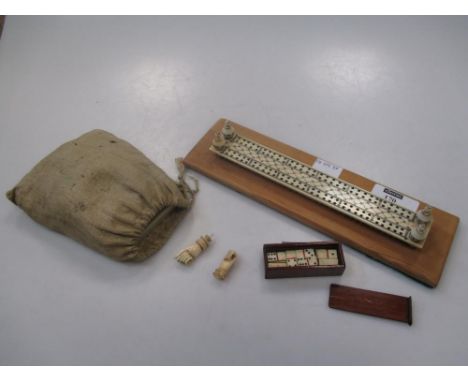 A 19th century bone cribbage board, with ‘hand’ marker and miniature dominos; and a bag of mother-of-pearl gaming counters  